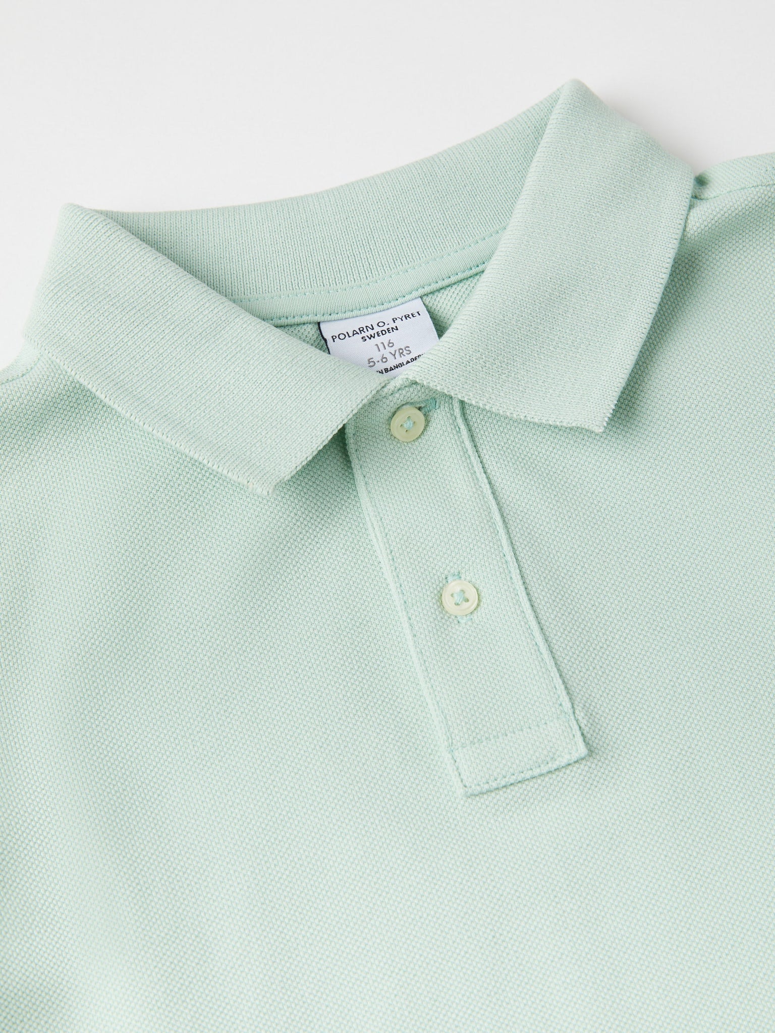 Green Kids Polo Shirt from the Polarn O. Pyret kidswear collection. Nordic kids clothes made from sustainable sources.