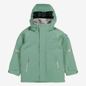 Kids waterproof shell jacket in colour green, with front pockets and detachable hood, made of lightweight and durable fabric.