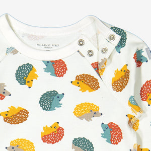 Close up of unisex hedgehog print organic cotton babygrow showing quality shoulder popper fastening for easy dressing