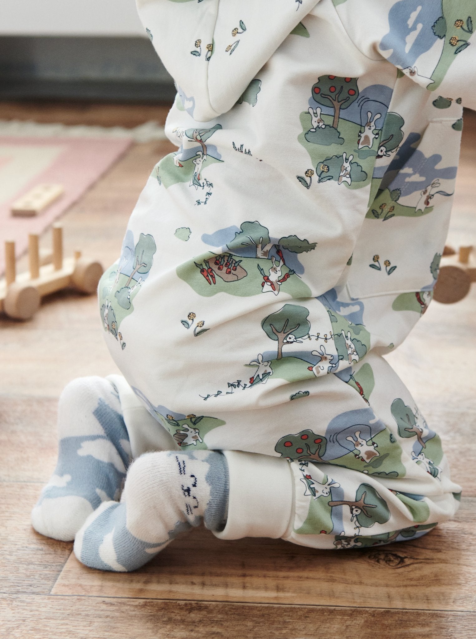 Close up of baby wearing unisex bunny print onesie in GOTS organic cotton. Paired with matching bunny print socks