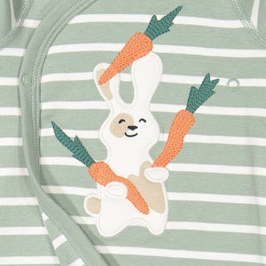 Close up of applique bunny eating carrots on green and white striped wraparound newborn babygrow. 