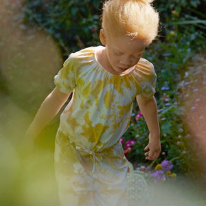 Tie-Dye Yellow Girls Playsuit from Polarn O. Pyret Kidswear. Made using sustainable sourced materials.