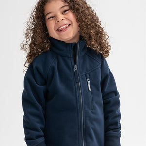 A smiling young kid wearing a waterproof kids fleece jacket in navy, with front zipper and pocket, made of 100% polyester.