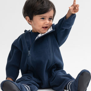 Baby boy wearing a navy windproof fleece baby pramsuit made with soft, flexible yet breathable fabric