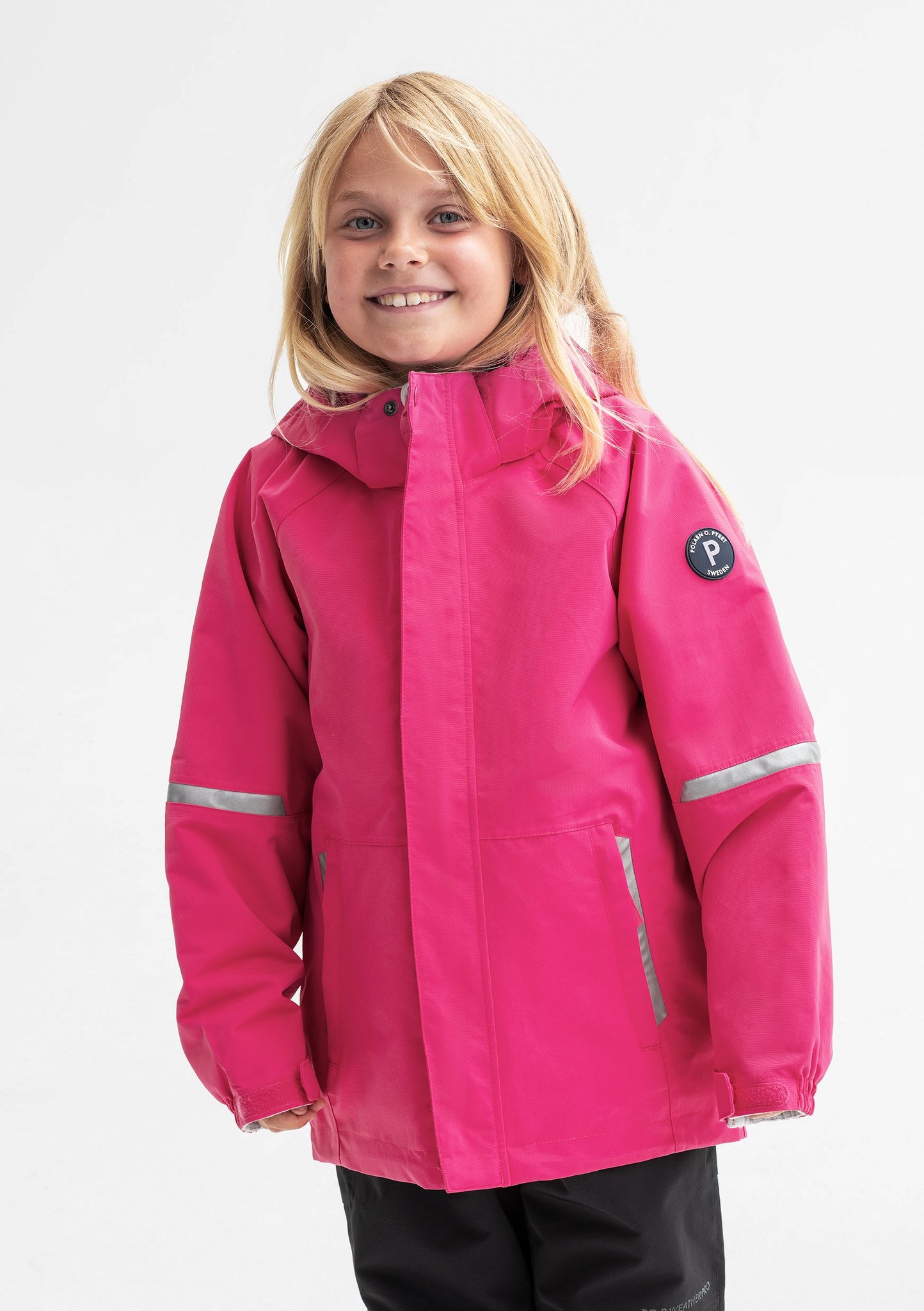 A young girl spotted wearing a pink, kids waterproof soft shell jacket, comes with reflectors, and detachable hood.