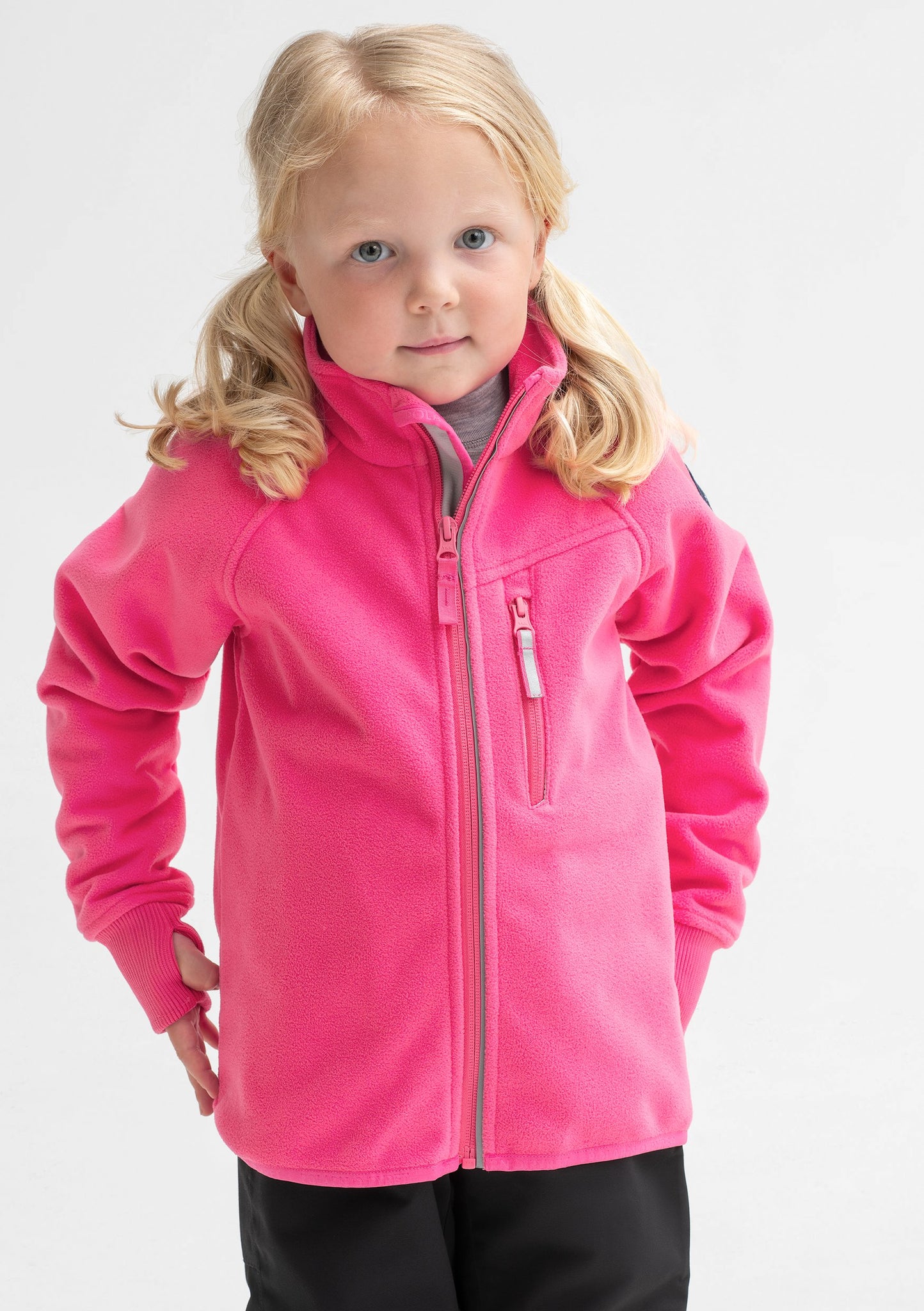 A young girl sporting a pink, kids waterproof fleece jacket made of breathable fabric, comes with cuff thumbholes.